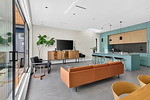 Open living room and kitchen with teal cabinetry at 262 West 19th Ave
