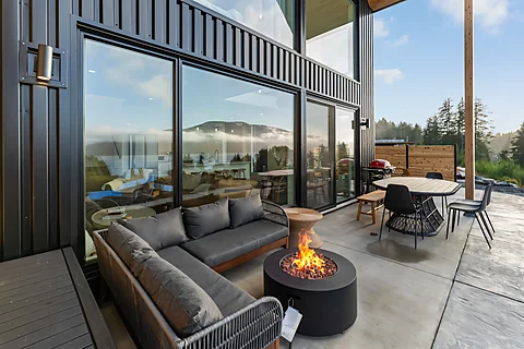 Evening fire pit on a deck overlooking mountains and water on the Sunshine Coast