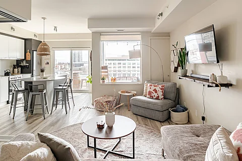 Bright urban condo living room with a connected kitchen and city views