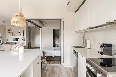 Modern condo kitchen opening onto a bright living area