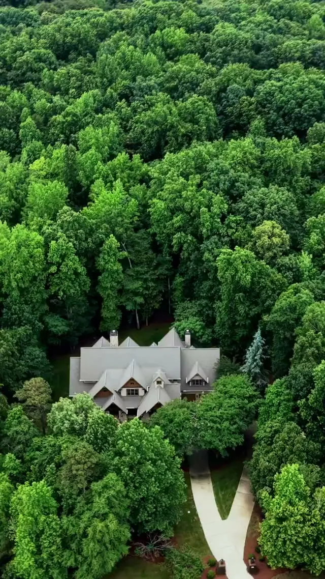 Vertical aerial video frame showing a coastal property and its surroundings